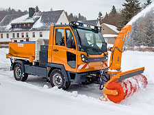 Kommunalfahrzeug befreit im Winter ein Wohngebiet von Schnee.